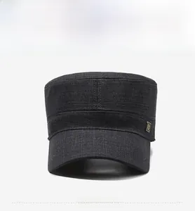 Front view of dark grey flat top military cap with cotton texture and gold metal logo