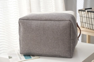 Detail of grey and beige cotton linen storage basket with premium leather handles