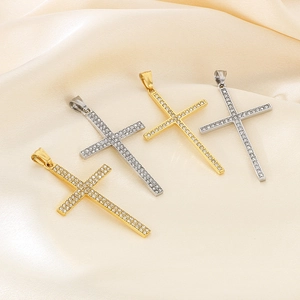 Close-up of gold and silver cross pendants with crystals on beige silk background