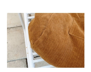 Detail of camel corduroy fabric showing thick vertical texture and sturdy side pocket seams