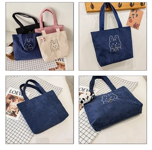 Detail of corduroy tote bags showing cute cartoon rabbit embroidery in four colors