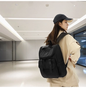 Rear view of a black high-capacity backpack with leather straps on a modern casual model