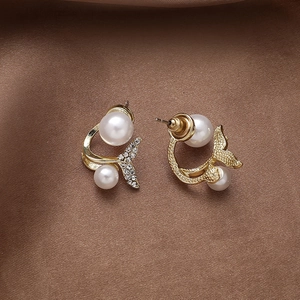 Elegant fishtail stud earrings with pearls and crystals in a golden metallic finish