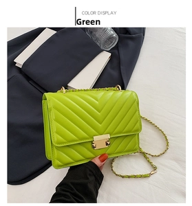 Macro shot of green V-quilted faux leather bag with gold rectangular twist lock clasp