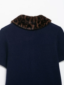 Detailed view of leopard faux fur collar on dark blue knit short sleeve top