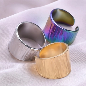 Detailed view of textured metal rings in gold, silver and aurora finishes on silk
