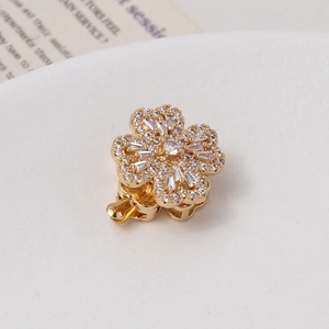 Macro detail of gold-plated rotating flower clasp with micro-set cubic zirconia stones