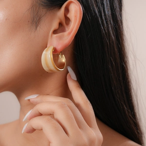 Macro detail of a vintage C-shape resin earring with tortoiseshell pattern and gold trim