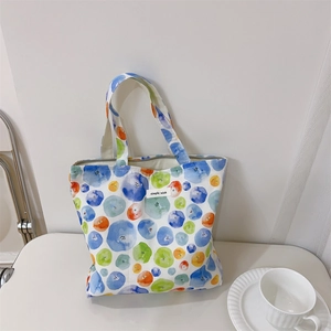 Cute watercolor polka dot cotton tote bag with zipper and simple wish label on white desk