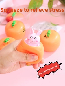 Close-up of hand squeezing orange carrot toy to pop out a cute pink bunny animal