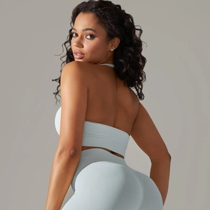 Detail of light blue seamless ribbed knit yoga bra and leggings set on female model