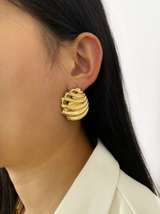 Close-up of elegant gold shell earrings worn by a model for a chic geometric look