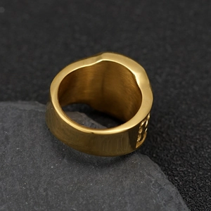 Detailed macro view of gold-plated eagle ring showing intricate side carvings on rock base