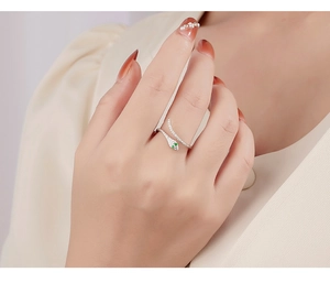 Detailed view of sterling silver snake ring with green zircon eyes and white stones
