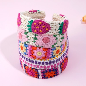 Detail of hand-crocheted headbands with floral and strawberry knit patterns for women