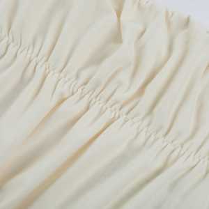 Détails du tissu en maille blanc cassé avec une texture froncée et des finitions soignées