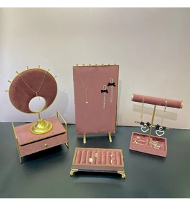 Detail of luxury dusty pink velvet jewelry display stands with gold metal frames