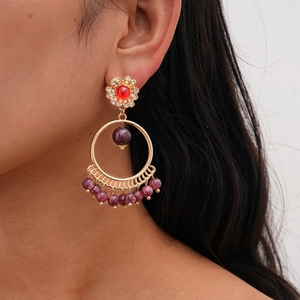 Detailed macro view of Bohemian style tassel earrings with rhinestones and purple beads