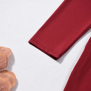 Close-up of red long sleeve cuff showing precise stitching and knit fabric texture