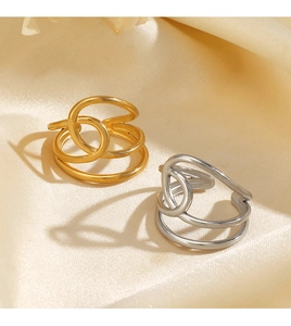 Détail de bagues minimalistes croisées en or 18 carats et argent sur soie