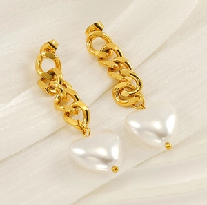 Detail of 18K gold stainless steel chain earrings featuring white heart pearl pendants