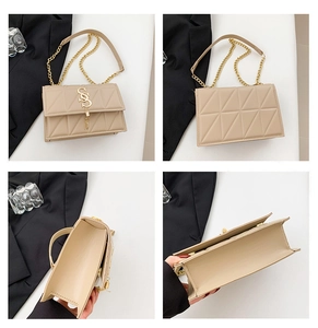 Detail view of beige quilted handbag with gold chain strap and organized compartments