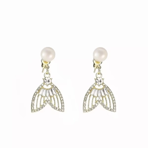 Détail de boucles d'oreilles queue de sirène dorées avec perles et pierres zircon