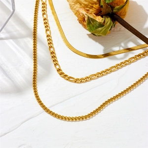 Three-layer gold necklace set featuring flat snake, curb, and Figaro link chains