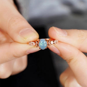 Vintage rose gold sun and moon ring featuring a polished oval blue opal and zircon