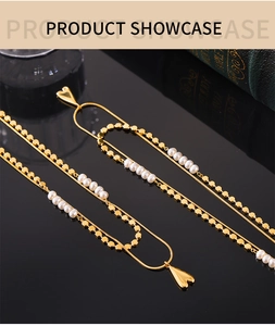 Détail d'un collier doré double couche avec pendentif cœur et perles d'eau douce