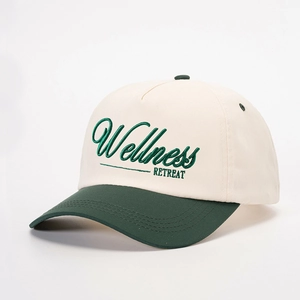 Two-tone baseball cap in cream and green with Wellness Retreat embroidery and adjustable strap