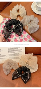Detail of three mesh bow scrunchies with rhinestones in black, beige, and gray colors