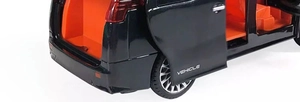 Macro view of black toy car showing open trunk and side doors with orange interior details