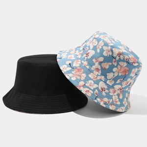 Detail of reversible bucket hats in plain black and light blue cherry blossom pattern