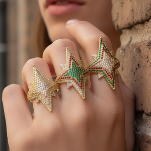 Three gold-plated starburst rings with white, red, and green zircon stones worn by a model