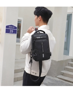 Close-up of black waterproof chest bag with functional zippers and white lettered webbing