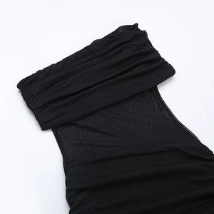 Détail de la maille transparente noire et du tissu plissé sur une robe sans bretelles