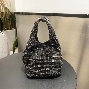 Close-up of black rhinestone bucket bag showing the sparkling crystal texture on a table