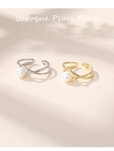Detail of adjustable crisscross gold and silver rings with elegant baroque pearls