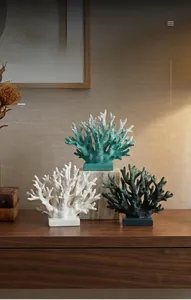 Detailed view of resin coral ornaments in white and green on a wooden shelf