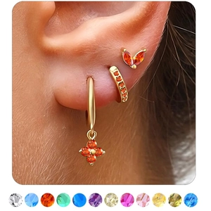 Detail of gold cartilage hoop earrings with orange charms and twelve color options