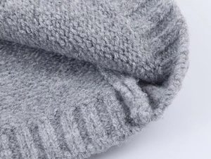 Detail of grey star jacquard knit cardigan with thick ribbed texture and wool blend fabric
