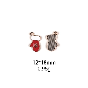 Detail of red and white enamel Christmas glove pendant with golden base and snowflake motif