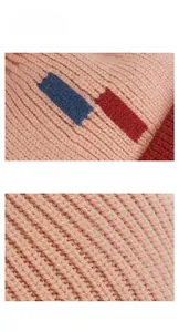 Detailed view of winter baby knit hat featuring thick pink yarn and color block patterns