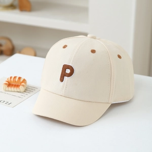 Detailed embroidery of brown letter P on a beige cotton kids baseball hat