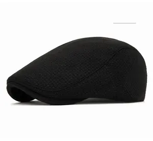Gros plan sur la casquette plate noire avec texture tissée à petits carreaux et laine