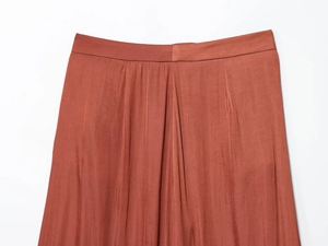 Detail van de taille en verticale textuur van de steenrode satijnen broek met hoge taille