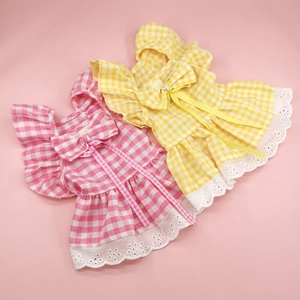 Detail of pink and yellow plaid pet dresses with lace trim and cute bows for dogs