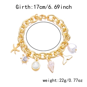 Detailed view of a gold ocean charm bracelet with starfish, turtle, and shell charms