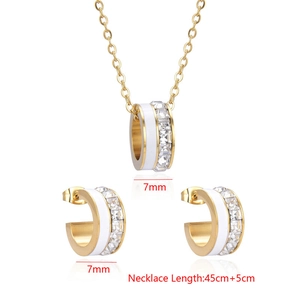 Detailed view of C-shaped earrings and necklace set with zircons and shell inlay